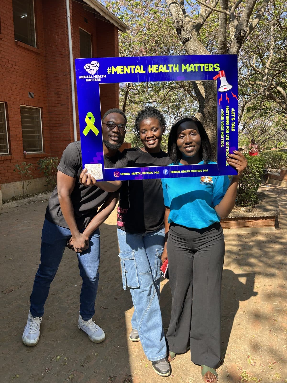 Group holding a community mental health awareness sign